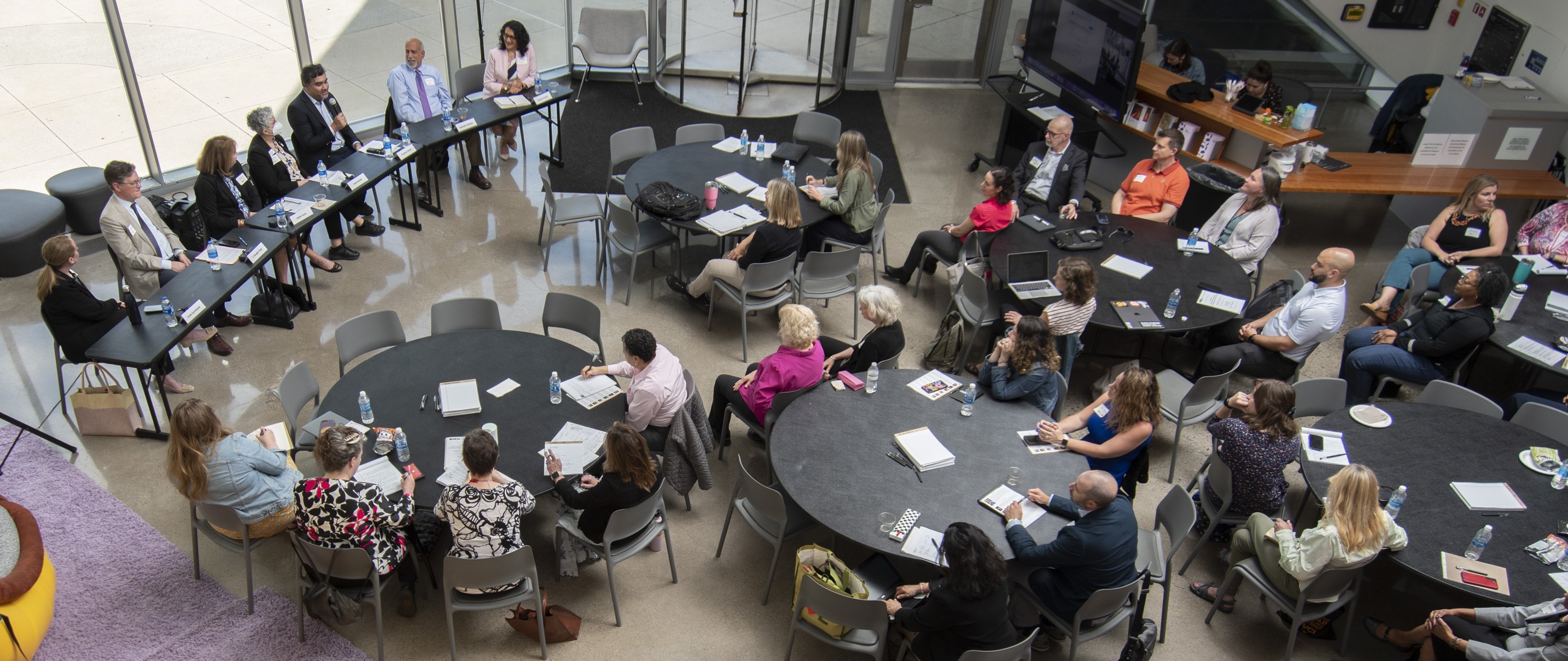 Image of panelists sitting at a table speaking to audience members at conference