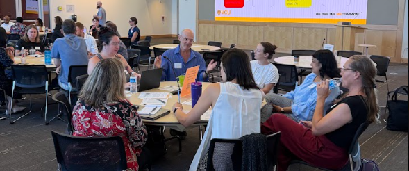 Faculty members engaging in group discussion at a round table